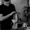 Man pouring hot water in a carafe with a white coffee filter